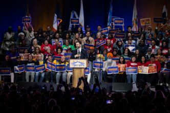 Close-up, high-angle portrait of New York City Mayoral candidate Zohran Mamdani smiling slightly.