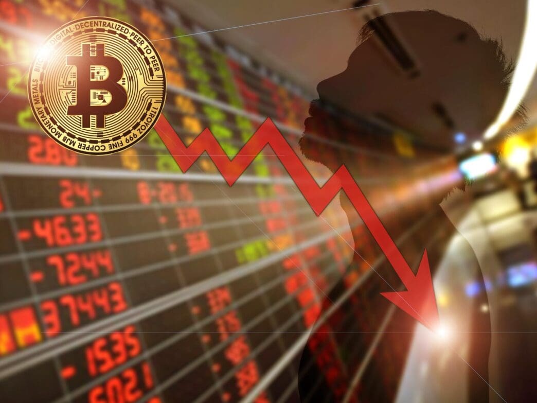 A graph depicts the declining value of Bitcoin, illustrating a financial crisis.