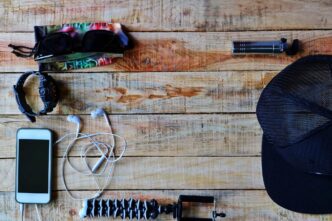 Overhead view of an assortment of items, such as a notebook, pen, and glasses, arranged on a wooden table.