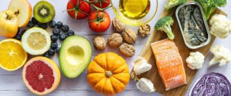 A colorful arrangement of citrus fruits, fresh vegetables, and fish represents a balanced and healthy diet.