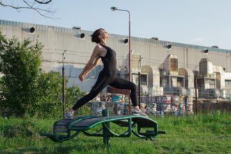 A woman in athletic wear is practicing yoga poses outside.