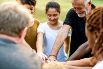 A diverse group of people hold hands, symbolizing unity and togetherness.