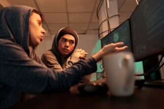 A group of shadowy figures huddled around computer screens, illuminated by the glow of code, illustrating a cyberattack in progress with a focus on data theft.