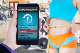 Happy Asian woman measuring her body in a gym, likely after a weight loss program.