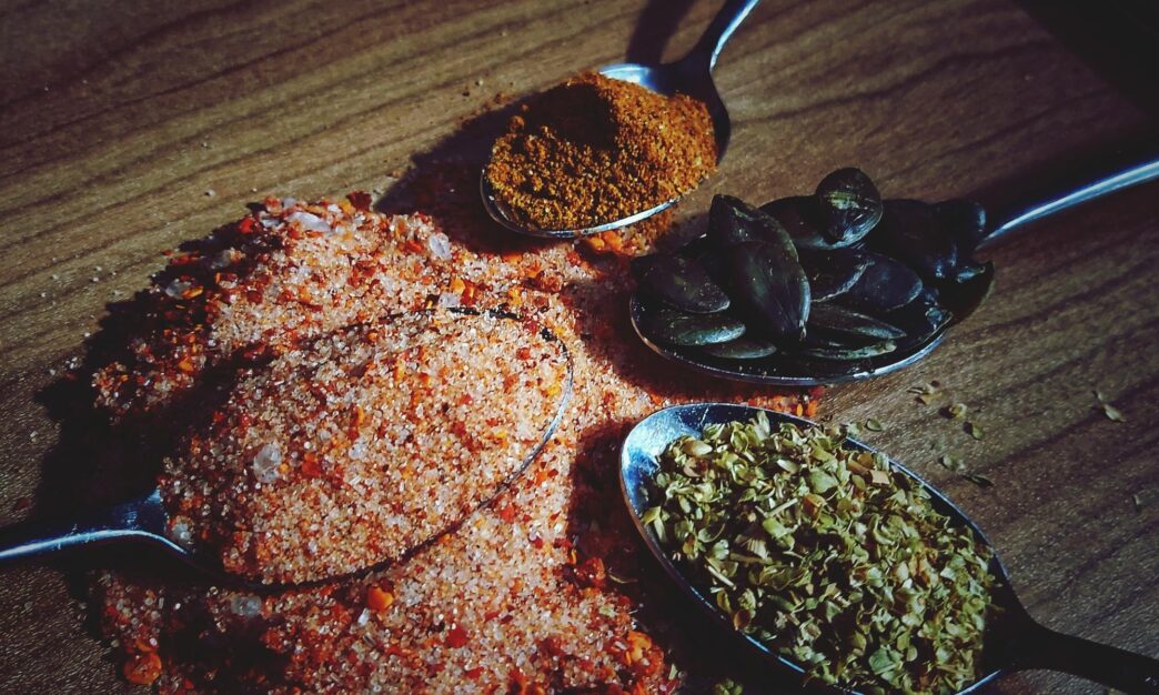 High-angle shot shows several spoons, each filled with a different ingredient, arranged on a table.