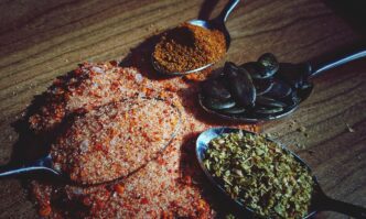 High-angle shot shows several spoons, each filled with a different ingredient, arranged on a table.