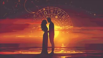 A couple on a beach embraces in front of a zodiac wheel.
