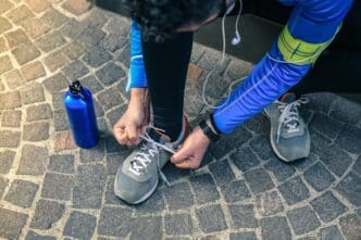 A man stretches while listening to music after a workout in an urban environment.