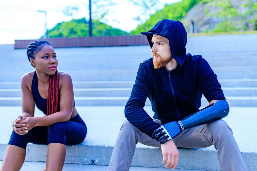 Two mixed-race friends work out together outside on a summer morning.