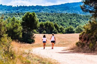 A mother and daughter walk together along a forest path in Anoia, Barcelona.