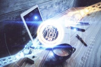 Hologram of the blockchain and crypto economy theme projected over a table with a computer in the background.