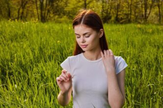 A young woman stands in a field, likely for a portrait.