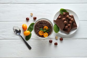 A person prepares chocolate mousse on a light-colored table.