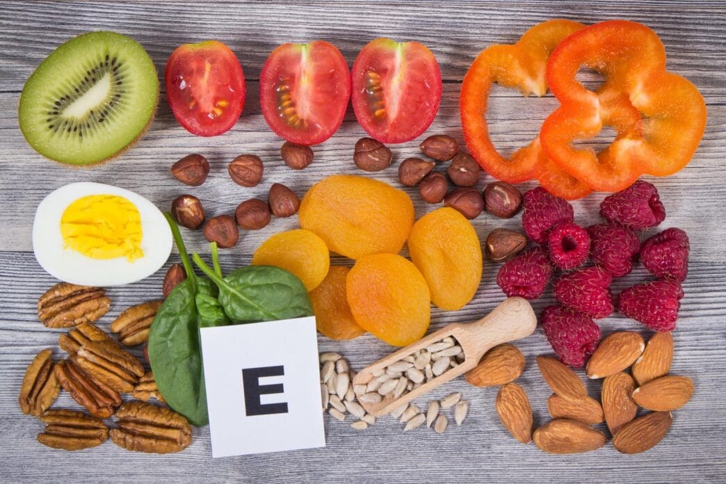 A collection of foods, including fruits and vegetables, highlights sources of vitamin E, minerals, and dietary fiber.