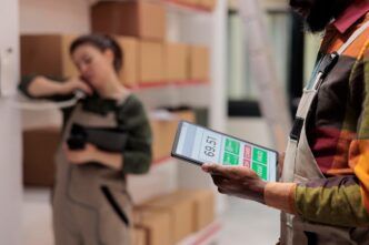 Warehouse supervisor in a high-visibility vest holding a tablet computer.