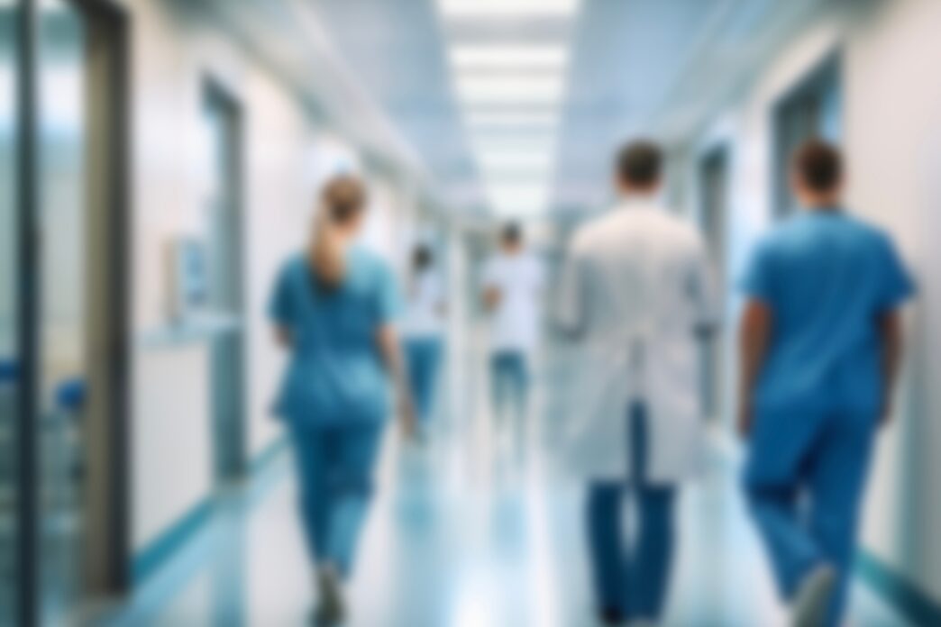 Blurred doctors and nurses walking in a hospital corridor