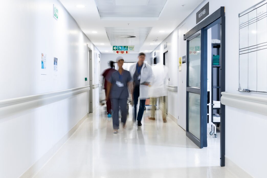 Diverse medical staff walking in a busy hospital corridor