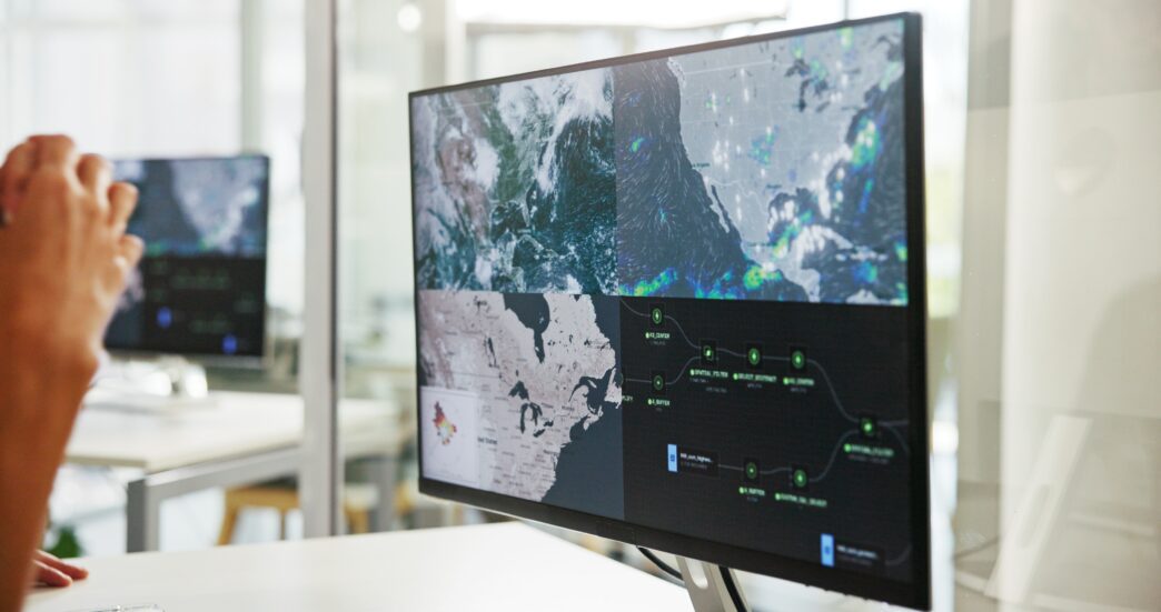 Person looking at weather monitors showing a severe storm map