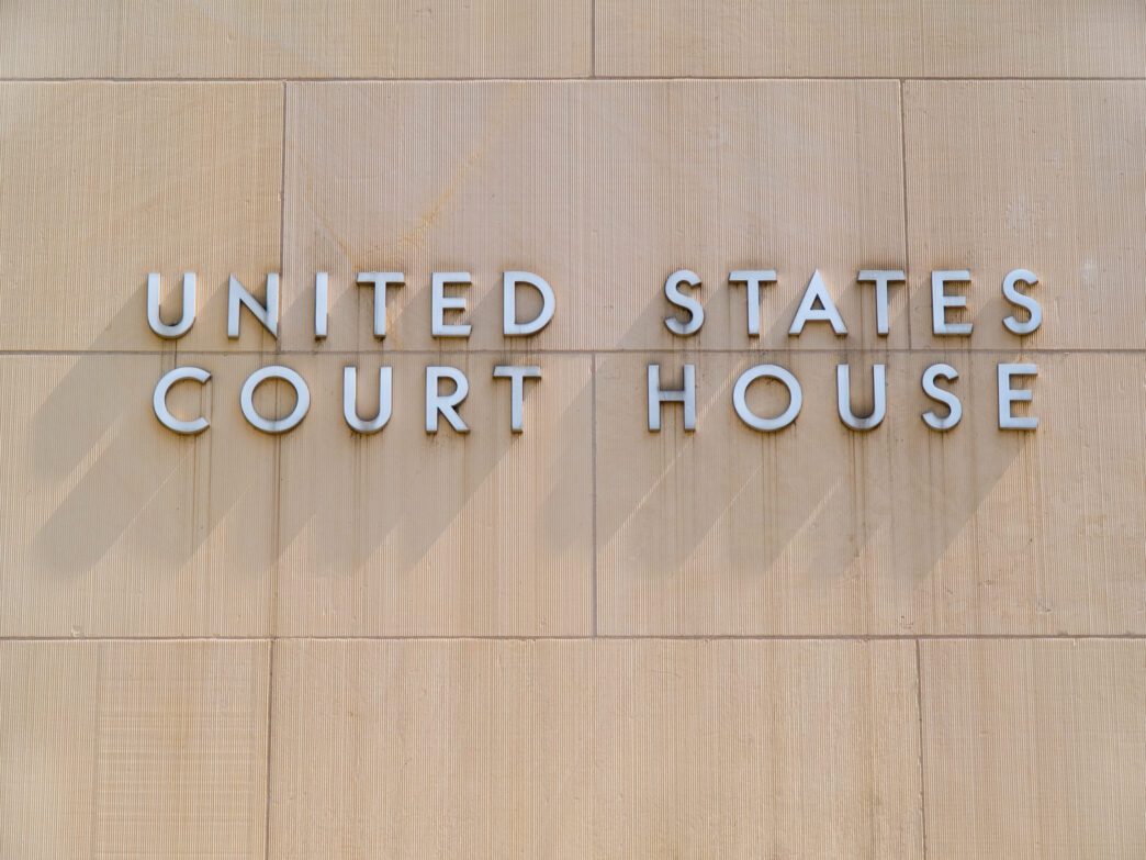 A sign identifies the building as a U.S. federal courthouse, photographed by David Gilder via Shutterstock.