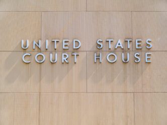 A sign identifies the building as a U.S. federal courthouse, photographed by David Gilder via Shutterstock.