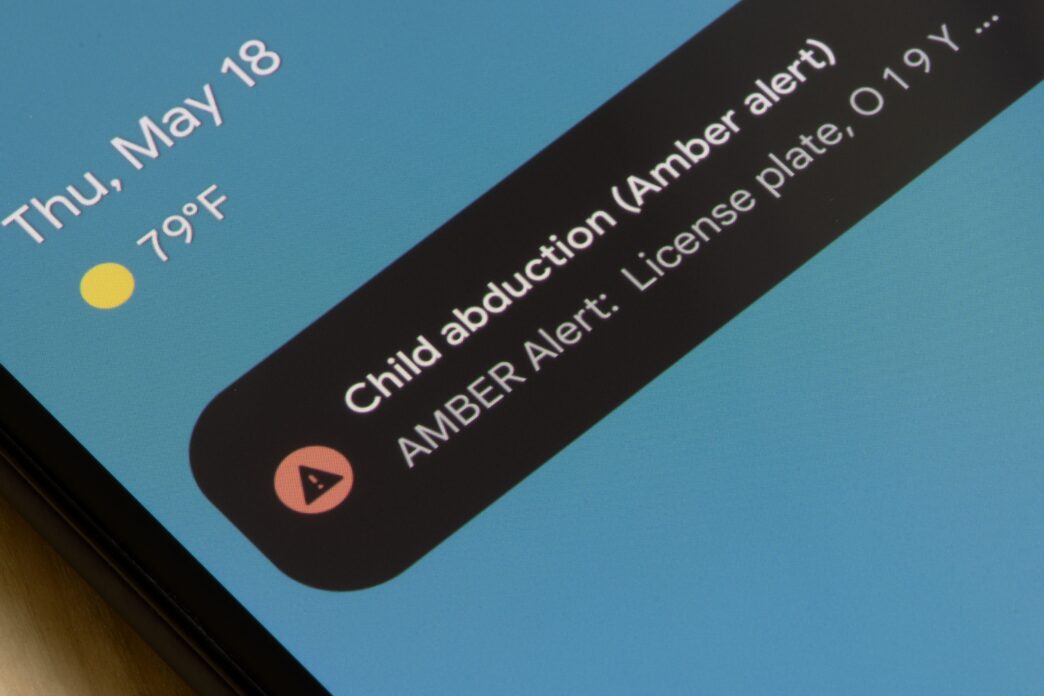 A smartphone lock screen displays an AMBER Alert notification for a child abduction case.