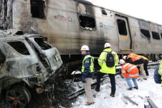 NTSB investigates Metro-North accident scene with damaged train and vehicle in Valhalla, NY.
