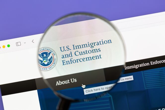 Magnifying glass highlights the U.S. Immigration and Customs Enforcement webpage under the Department of Homeland Security.