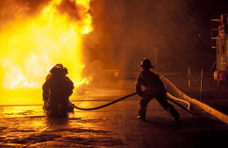 Firefighters extinguishing a large fire at night using hoses, as seen in the filename "firefighters-extinguishing-fire__MDL".