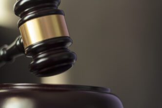 A judge's gavel is hitting a block, symbolizing law and justice in action.