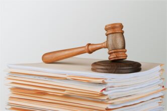 A judge's gavel rests on a stack of documents, indicating legal context and decision-making.