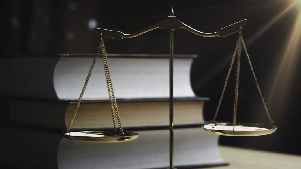 Scales of justice in front of legal books symbolizing law and justice concepts.