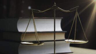 Scales of justice in front of legal books symbolizing law and justice concepts.