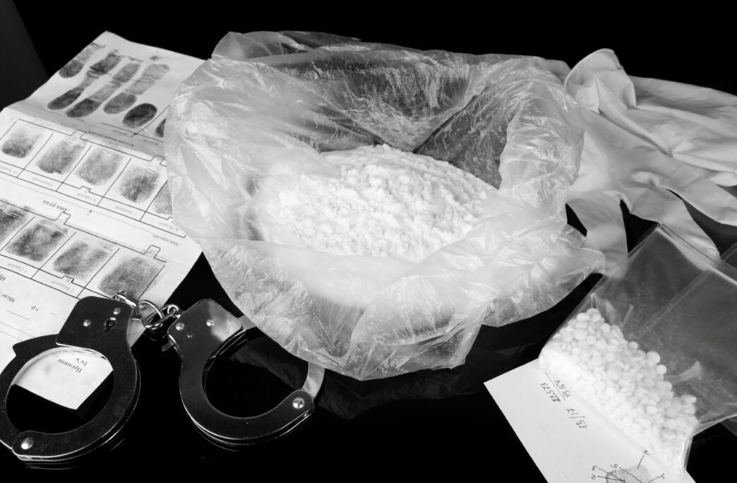 Drugs and weapons evidence with fingerprints, handcuffs, and substances linked to filename Drugs_Weapons-07_1.