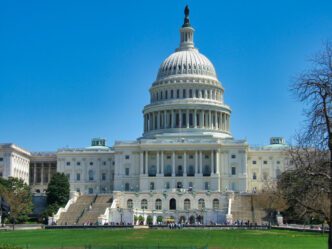 The United States Capitol building in Washington, D.C., under a clear blue sky.