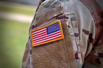 US Army soldier's uniform featuring an American flag patch in close-up.