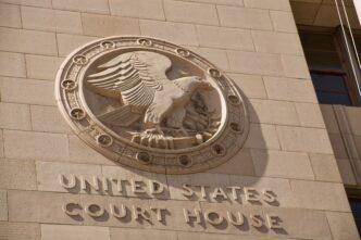 Courthouse building exterior with "United States Court House" signage during the day, photo by Elliott Cowand Jr via Shutterstock.