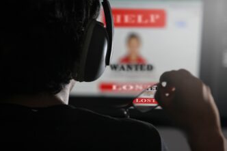Person with headphones views a screen displaying help, wanted and lost poster.