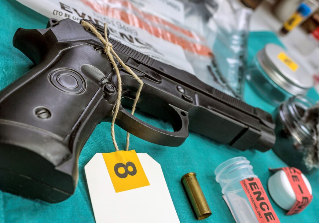 Evidence display of a firearm and related items, tagged as Drugs_Weapons-10_1.