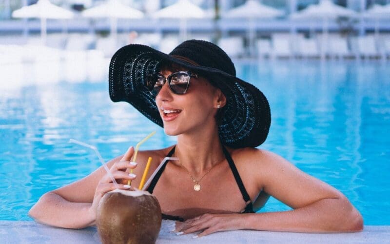 Woman in a Miami Beach hotel pool drinking a coconut cocktail