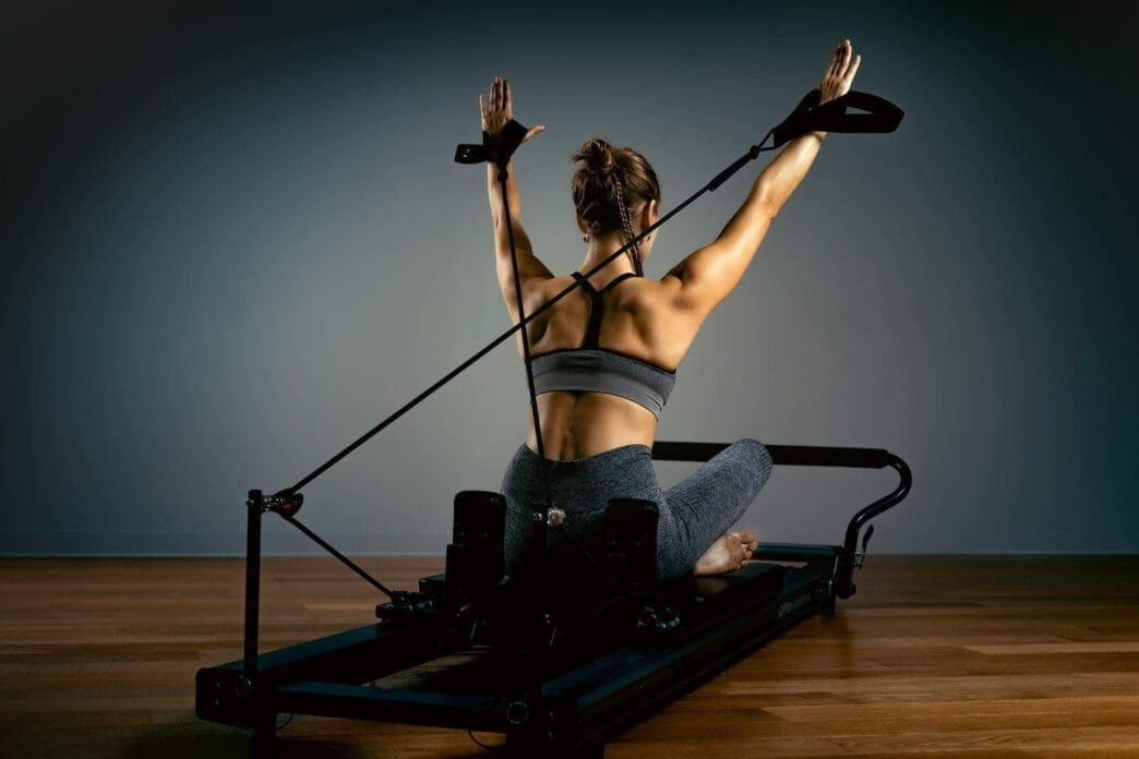 Young girl doing Pilates exercises with a reformer couch