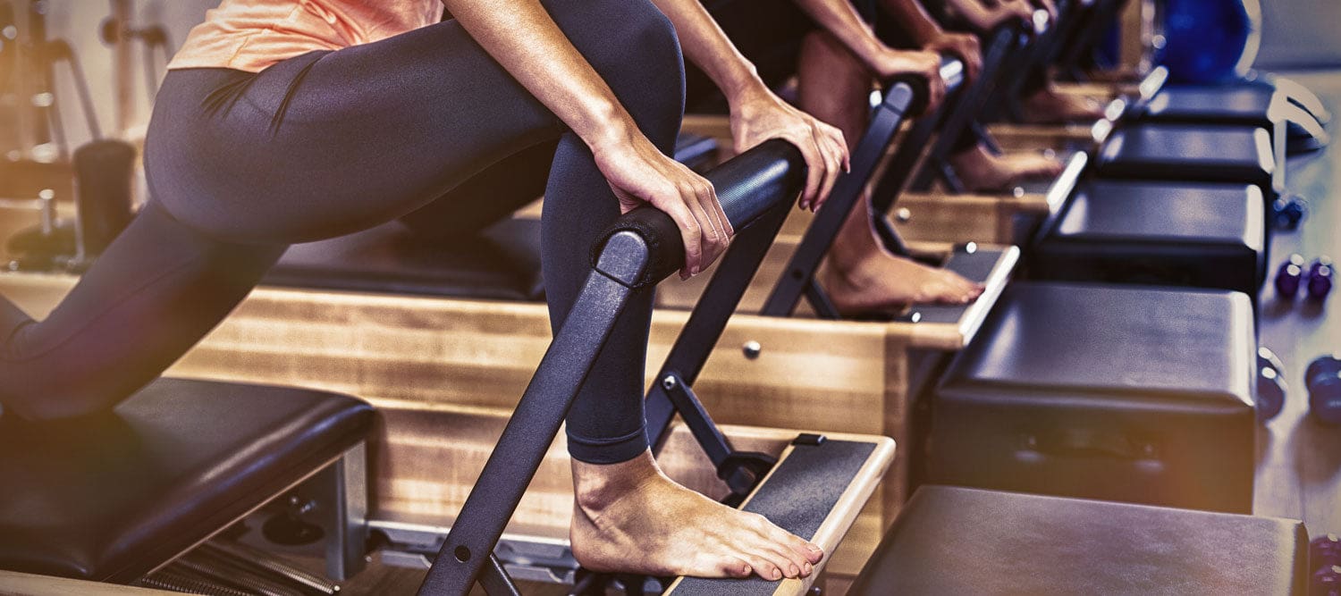Group of women exercising on Pilates reformer in gym in Miami